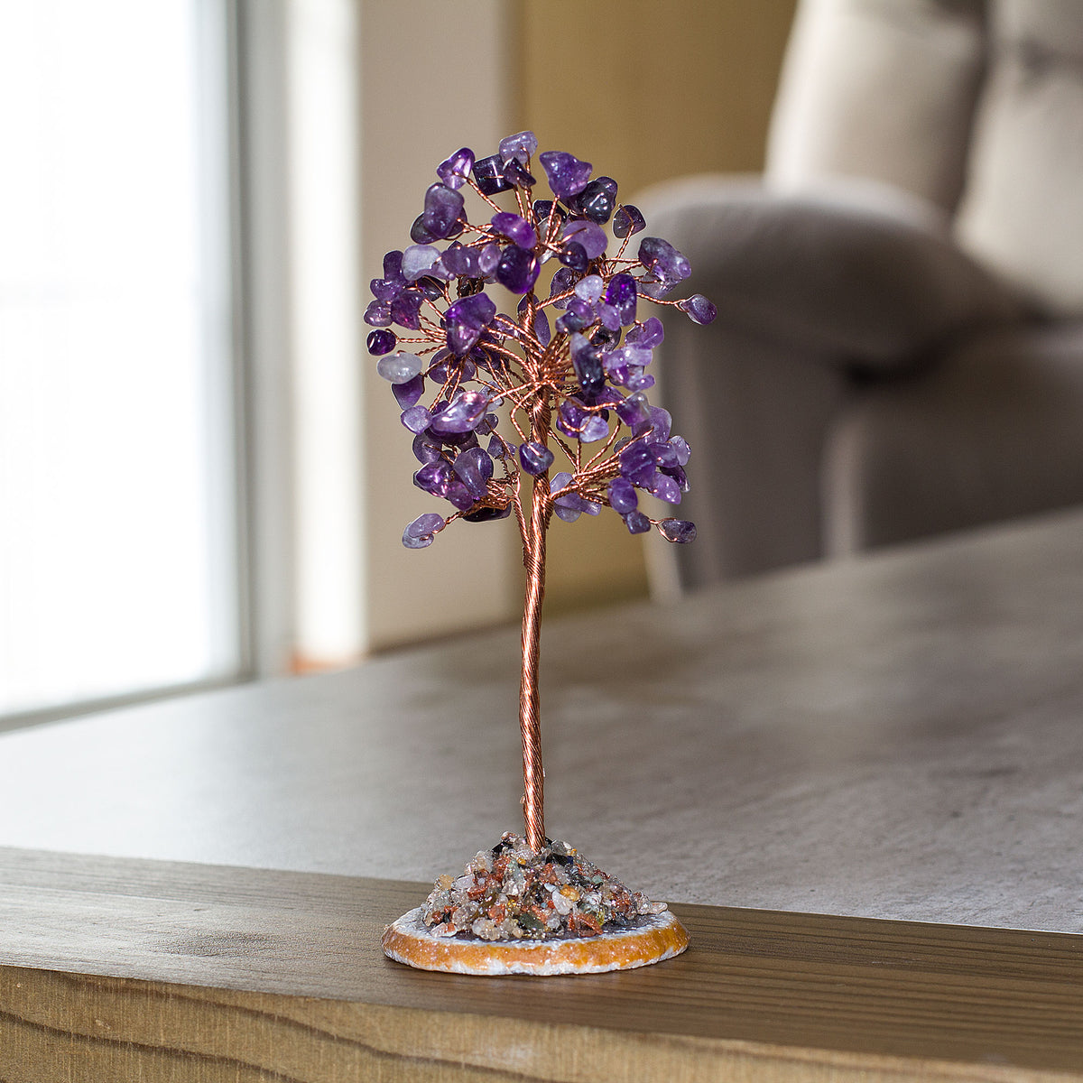 Introducing a truly remarkable piece of art - the sleek, sophisticated, and stunning Crystal Gemstone Tree of Life. This magnificent creation is adorned with exquisite crystal chips that sparkle and shine beautifully, set on a agate slice base giving it a unique charm that is second to none. This masterpiece will add a touch of elegance and refinement to any space, be it your home, office, bathroom, or any other place that deserves a touch of class. Get ready to experience an unparalleled level of taste and