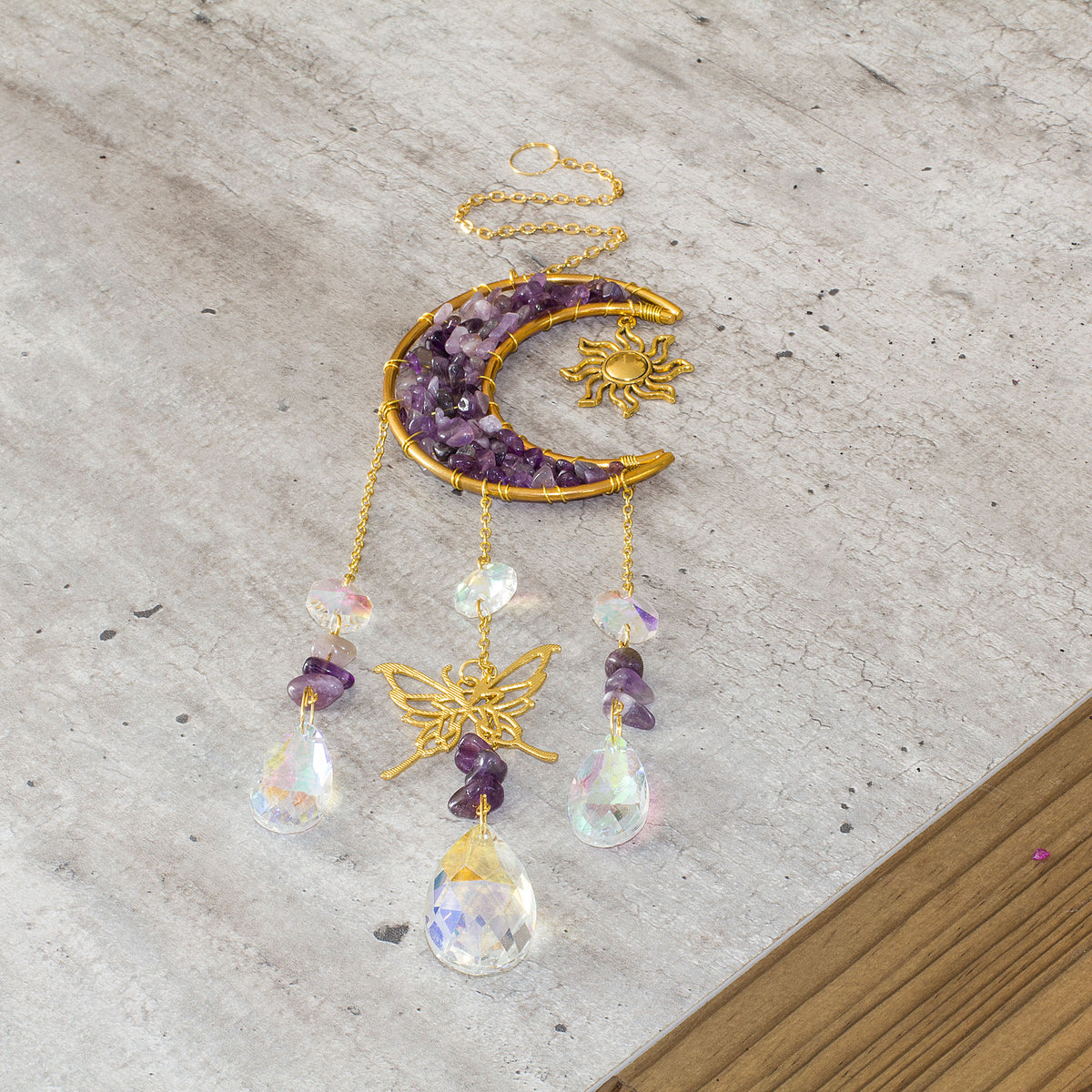 Transform your living space with the captivating beauty of this exquisite crystal chip suncatcher. Watch in wonder as the glass teardrop reflects a stunning array of rainbow colors, spreading their vibrant beauty throughout your home. The suncatcher is adorned with a celestial theme, featuring the sun, moon, and an elegant butterfly, adding a touch of warmth and comfort to your living space. Elevate your home decor with this enchanting and mesmerizing suncatcher.