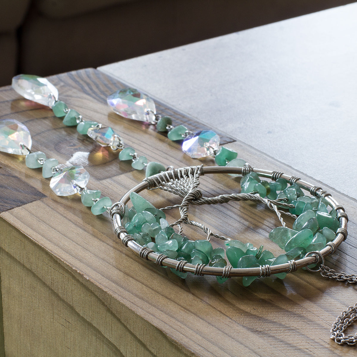 Enhance the ambiance of your living space with the enchanting allure of this stunning crystal chip suncatcher. Experience the mesmerizing spectacle as the glass teardrop scatters a breathtaking spectrum of rainbow hues, casting a spellbinding and vibrant radiance throughout your home. Adorned with a crystal chip tree of life, this suncatcher exudes a sense of warmth and tranquility, adding a touch of elegance to your home decor. Elevate the atmosphere of your living space with this captivating and spellbind