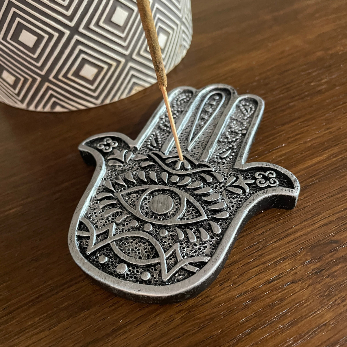 Hamsa Hand Metal Incense holder (Silver) Mi Chakra - Introducing a stylish metal Hamsa Hand incense holder, a beautifully crafted piece that seamlessly blends elegance with functionality. This unique design not only enhances the aesthetic of your space but also serves as a perfect resting place for your favorite incense sticks. The intricate detailing of the Hamsa hand symbolizes protection and good fortune, making it a meaningful addition to your home decor. Whether you&#39;re looking to create a serene atmosp