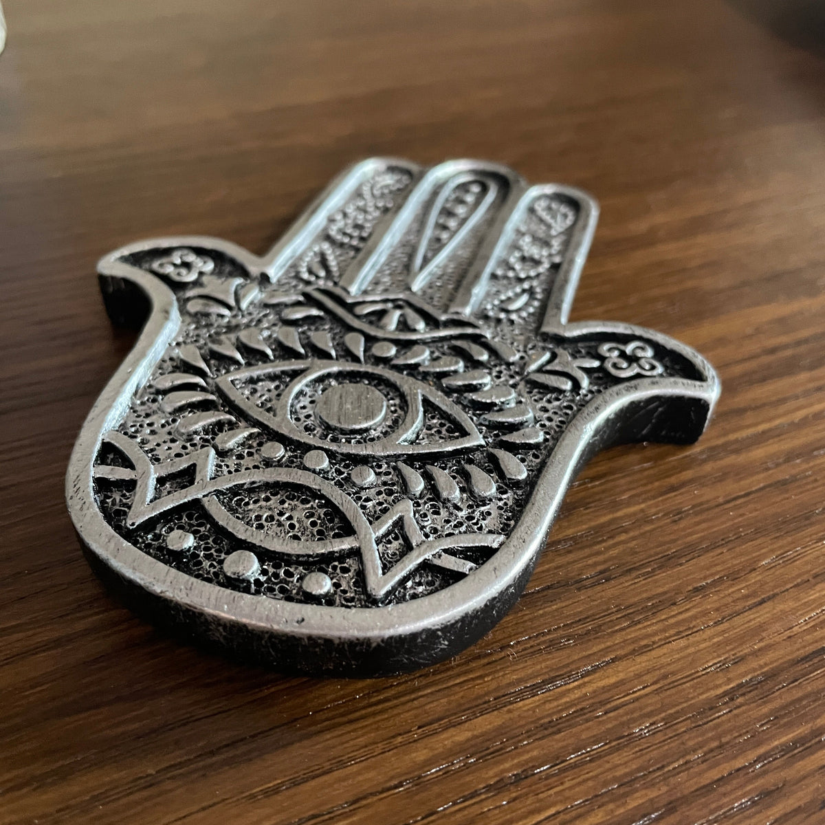 Hamsa Hand Metal Incense holder (Silver) Mi Chakra - Introducing a stylish metal Hamsa Hand incense holder, a beautifully crafted piece that seamlessly blends elegance with functionality. This unique design not only enhances the aesthetic of your space but also serves as a perfect resting place for your favorite incense sticks. The intricate detailing of the Hamsa hand symbolizes protection and good fortune, making it a meaningful addition to your home decor. Whether you&#39;re looking to create a serene atmosp