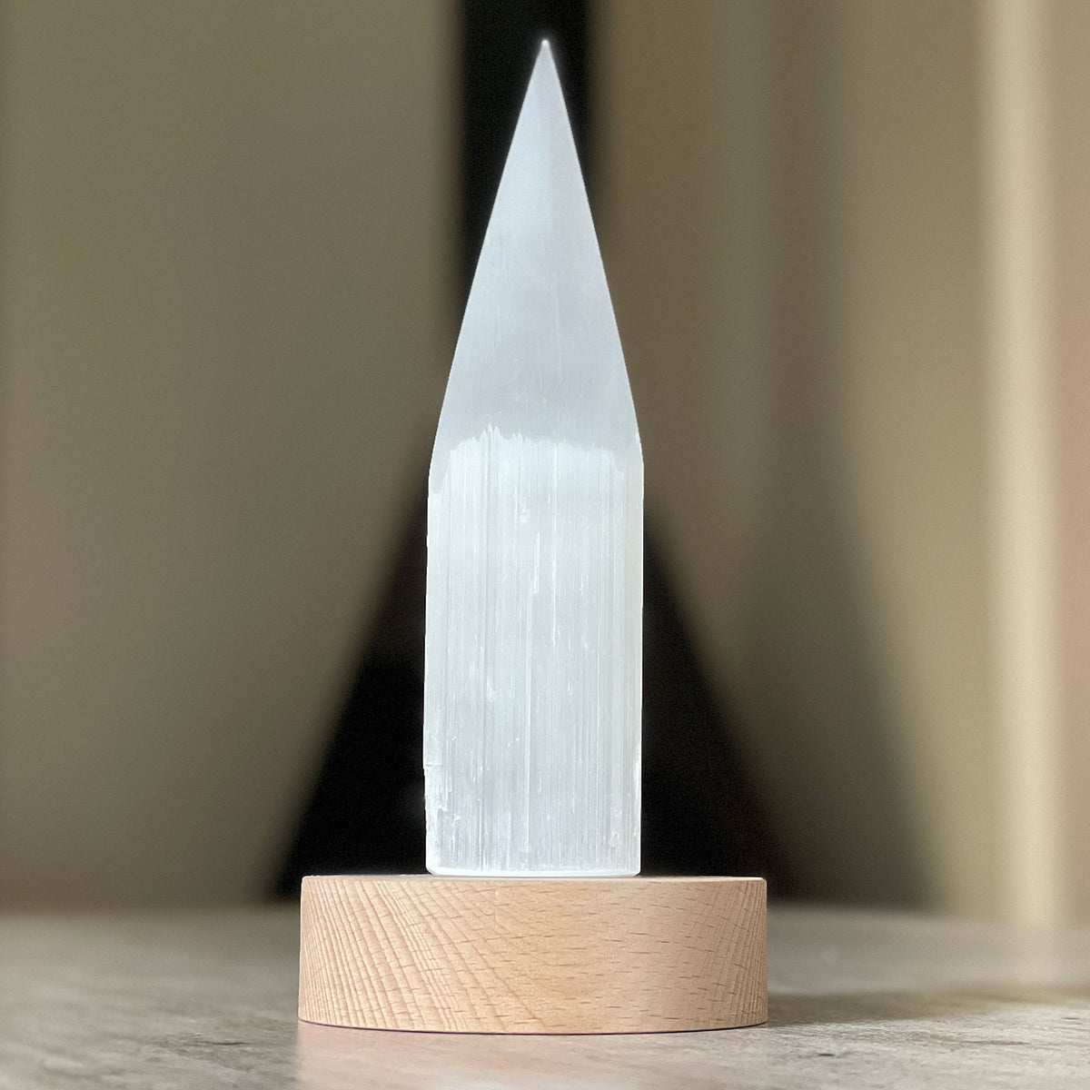 Selenite Lamp - Pencil Point Small - Selenite is a beautiful and versatile crystal that offers numerous benefits, making it a popular choice for both decor and holistic purposes. Its natural beauty and unique translucent appearance make it an eye-catching addition to any home. Selenite emits a soft and warm glow, which makes it an excellent choice for a night light.