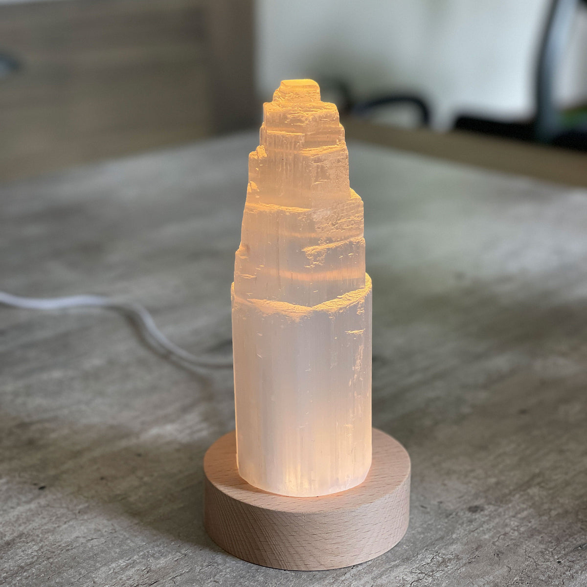 Selenite Lamp - Tower Large - Selenite is a beautiful and versatile crystal that offers numerous benefits, making it a popular choice for both decor and holistic purposes. Its natural beauty and unique translucent appearance make it an eye-catching addition to any home. Selenite emits a soft and warm glow, which makes it an excellent choice for a night light.