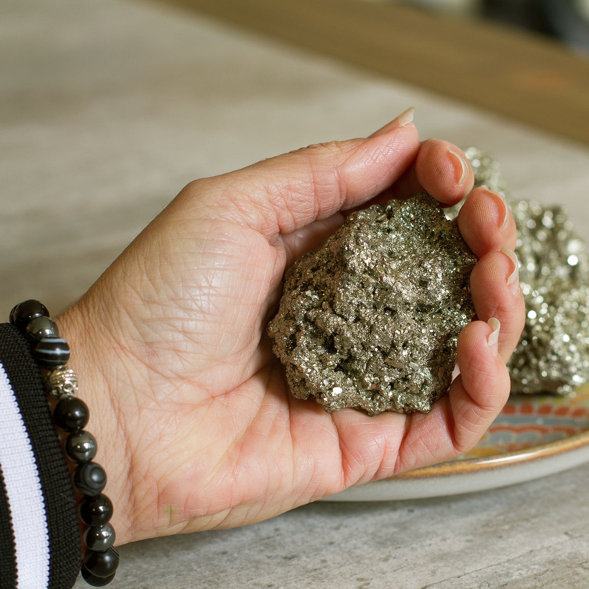 Pyrite Cluster / Druse - +/_ 165g - The term &quot;pyrite&quot; is derived from the Greek word &quot;pyr,&quot; which means fire. This is because the mineral has a distinct golden hue that resembles the color of fire. Pyrite is a fascinating gemstone that has a unique property of producing small sparks when it comes in contact with steel.
