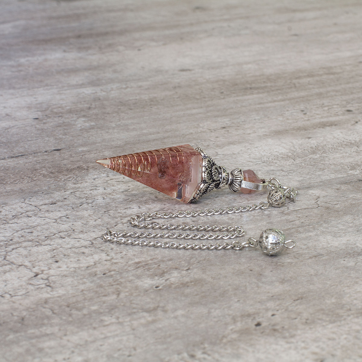 A crystal pendulum is a simple tool commonly used for divination and dowsing. It typically consists of a crystal or gemstone suspended on a chain or cord. The crystal is usually pointed, allowing it to swing freely and respond to questions. Pendulums are believed to connect with your subconscious mind and energy fields, offering insights through their movements.