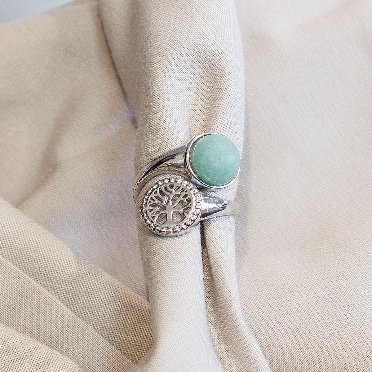 Are you drawn to the calming and grounding influence of crystals, and the liberating lifestyle they symbolize? If so, immerse yourself in the sheer beauty of our exclusive assortment of crystal rings. These exquisite wrap-around adjustable rings are a sight to behold, featuring a dazzling tree of life intricately set in a mesmerizing circular pattern, accentuated by a captivating and flawlessly cut round cabochon crystal at its center.