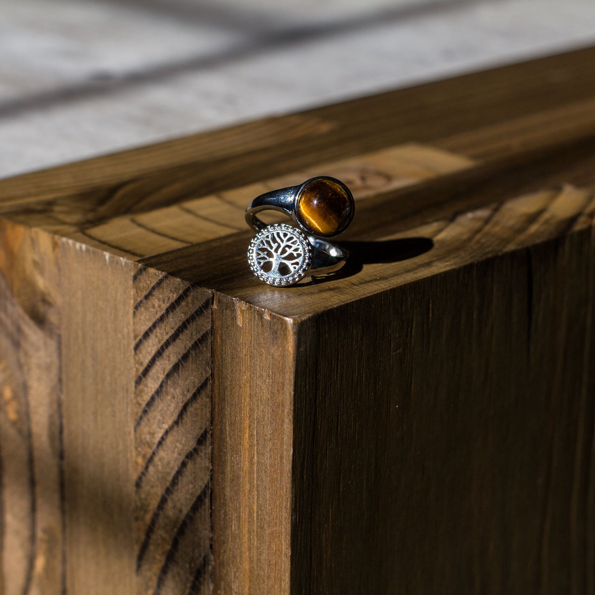 Are you drawn to the calming and grounding influence of crystals, and the liberating lifestyle they symbolize? If so, immerse yourself in the sheer beauty of our exclusive assortment of crystal rings. These exquisite wrap-around adjustable rings are a sight to behold, featuring a dazzling tree of life intricately set in a mesmerizing circular pattern, accentuated by a captivating and flawlessly cut round cabochon crystal at its center.